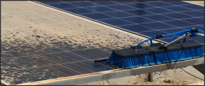 solar panel being cleaned by heavy machine