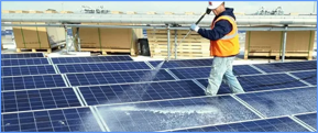 solar panel being cleaned by worker